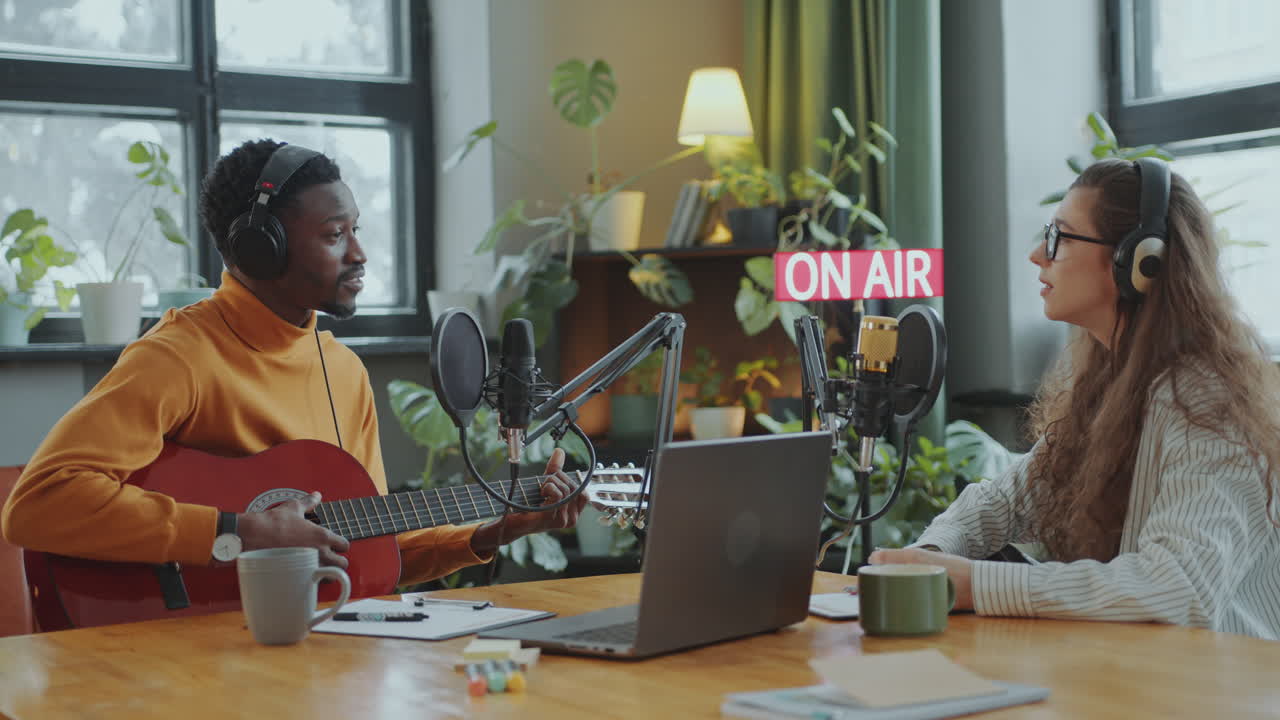 Musician Singing to Guitar during Radio Show in Recording Studio