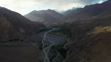 toma cinematográfica de drones del valle debajo del pico tupopdan, conos passu en hunza pakistán, amplia toma aérea en movimiento lento con el río hunza
