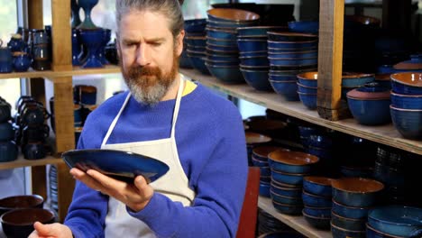 Male-potter-examining-a-earthenware-bowl