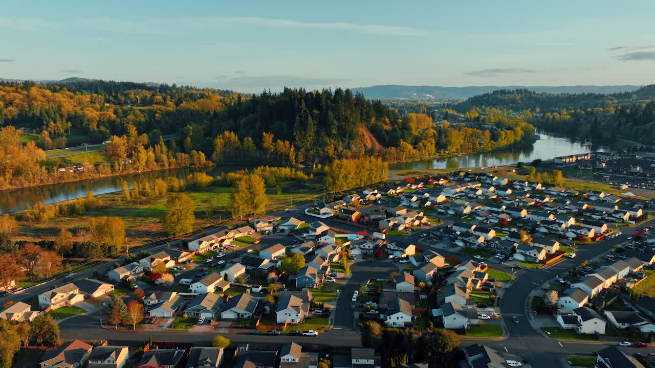 Lovely rural neighborhood along the narrow river in the rays of setting sun. Beautiful lush greenery surrounding the area. Top view.
