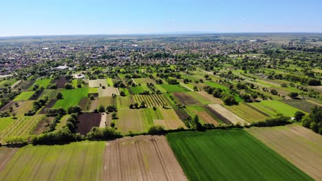 the edge of a town with fields and gardens, drone shot on a sunny day