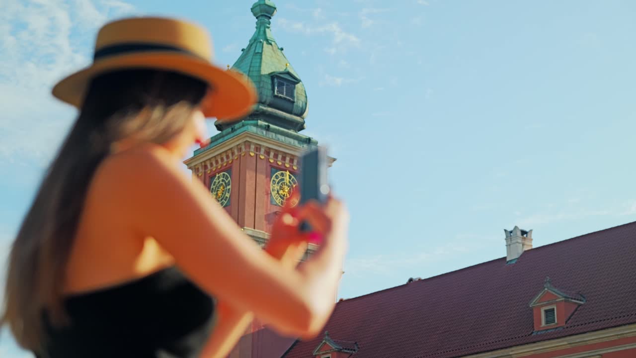 Slow motion focus shift from Royal Castle to woman filming with phone