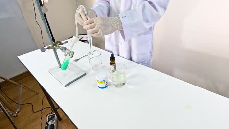 scientist conducts a chemical reaction with copper carbonate and sulfuric acid in a lab setting