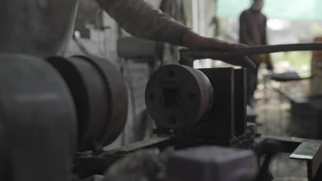 metal workers during forging process, lathe hot spinning in a workshop