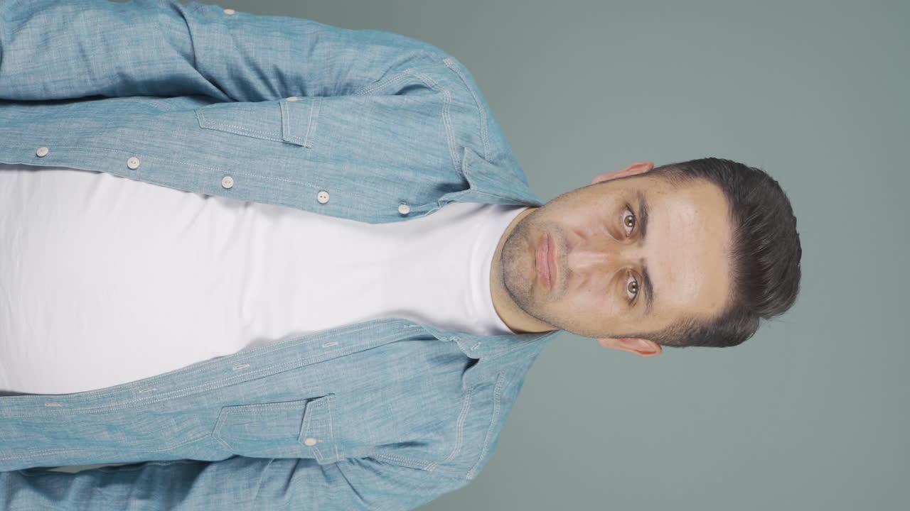 video vertical de un hombre mirando deprimido a la cámara.