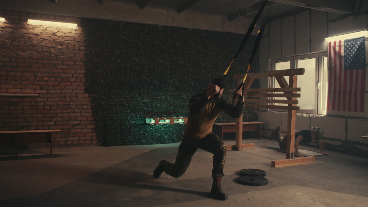 Man doing suspension training exercises in a gym