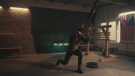 man doing suspension training exercises in a gym