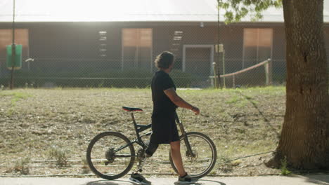 side view of man with disability walking with bile outdoors