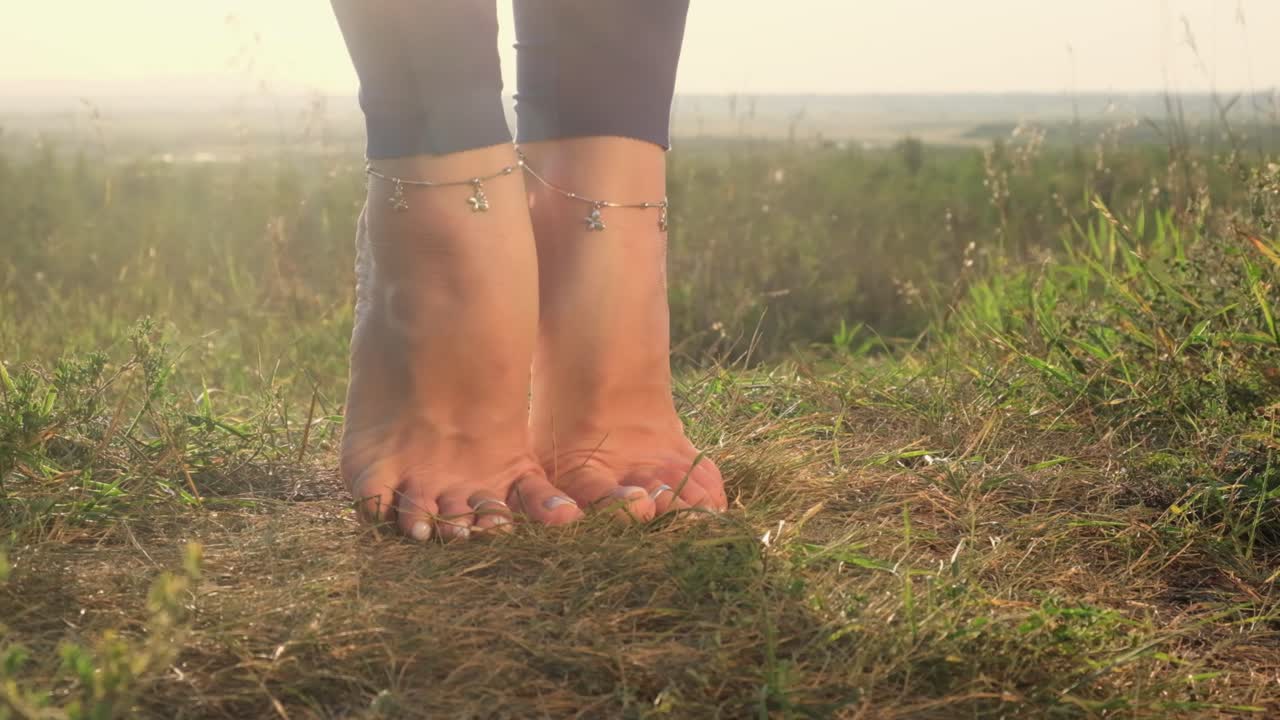 Woman practicing yoga barefoot outdoors