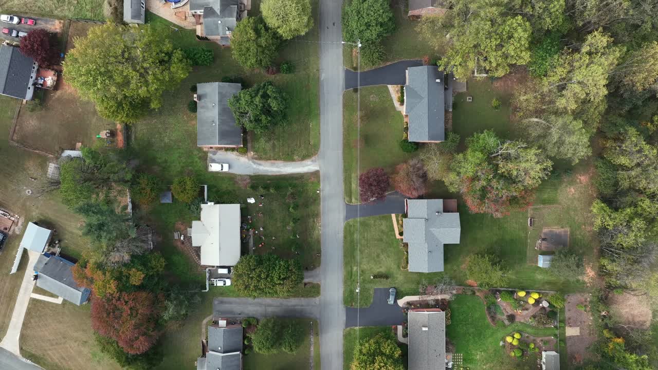 Calm American suburban neighborhood from above. aerial view of with single-family homes, curved roads, autumn trees and spacious green yards im peaceful residential area of American town