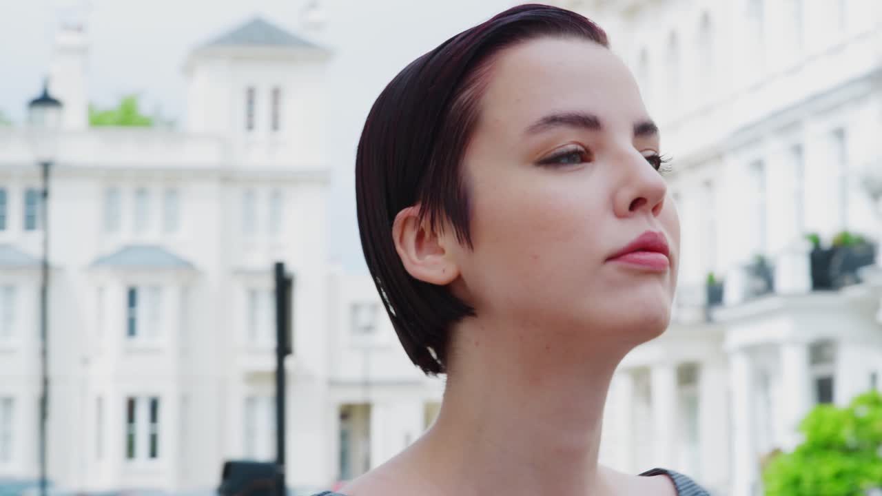 도시 거리에서 야외에 서 있는 패션 의식을 가진 젊은 여성