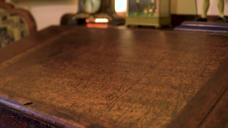 clsoe up of antique writing table visible marks scratches it was used heavily back in the days slow motion