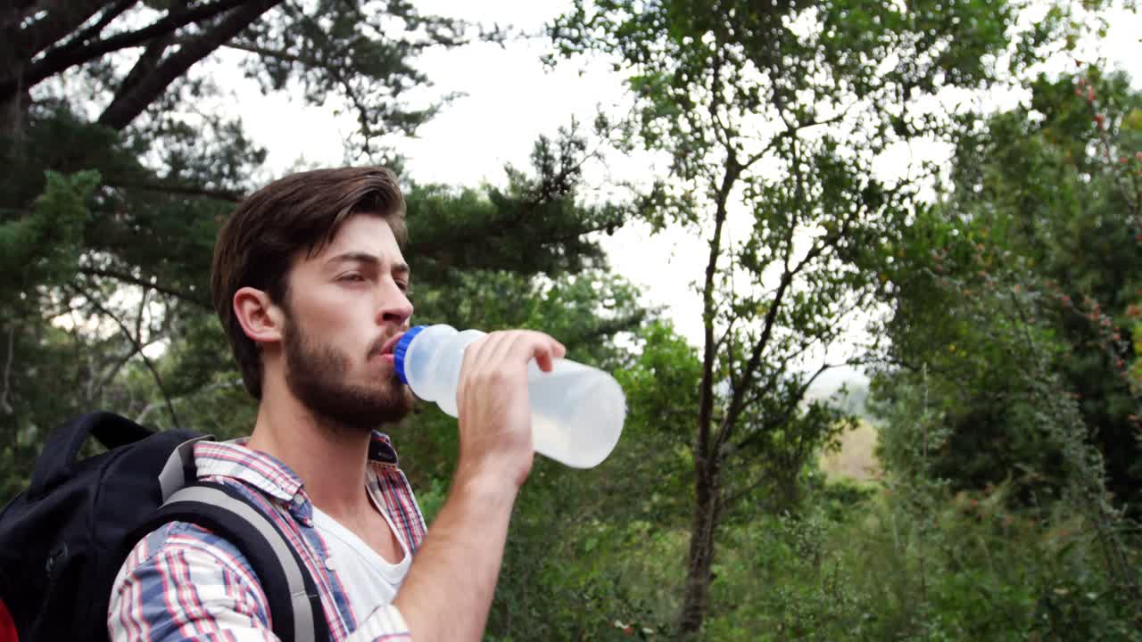 hombre bebiendo agua mientras camina
