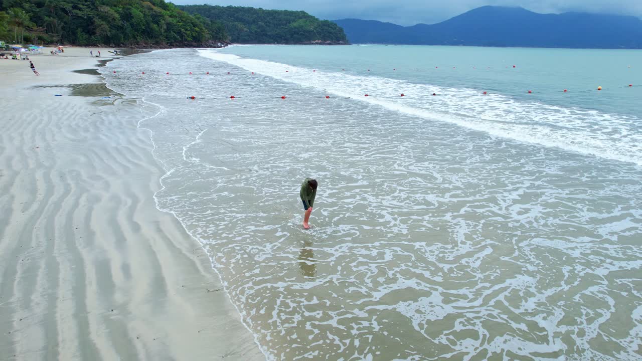 바다 해안에 부서지는 바다 파도를 즐기는 남자