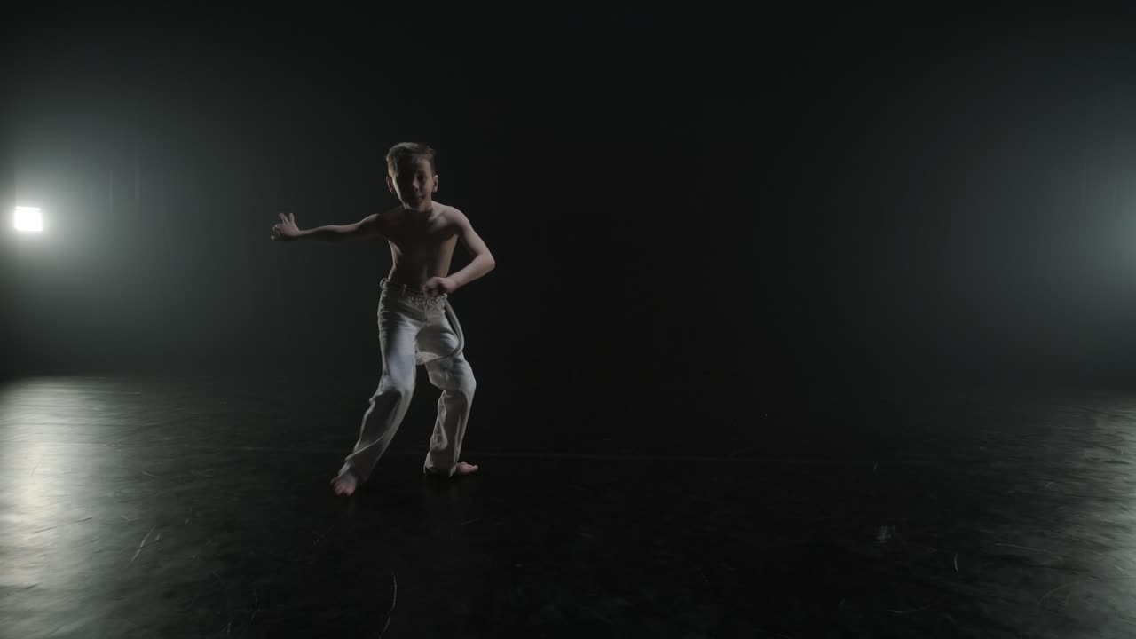 combattenti di capoeira che eseguono mosse dinamiche sul palco. arti marziali, danza e acrobazie in azione. atleti a petto nudo che mostrano forza, flessibilità e tecnica sotto i riflettori