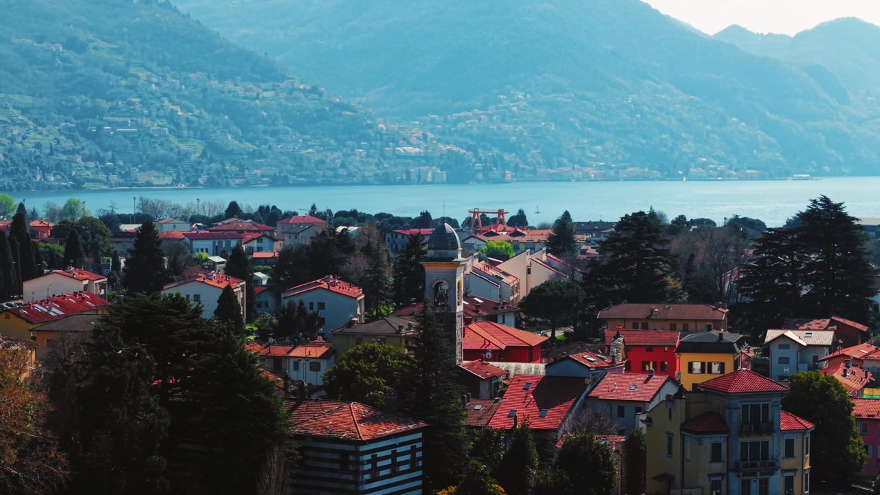 Sorvolo con drone di un villaggio del Lago di Como e acqua cristallina.