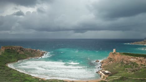 AERIAL:-Black-Clouds-Surrounds-Ghajn-Tuffieha-Beach-on-a-Gloomy-Winter-Day