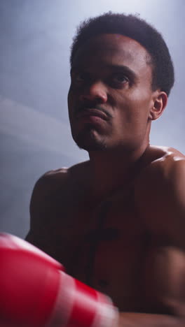 Vertical-Video-Of-Tattooed-Male-Boxer-Wearing-Gloves-Warming-Up-Throwing-Punches-And-Sparring-Before-Start-Of-Boxing-Match