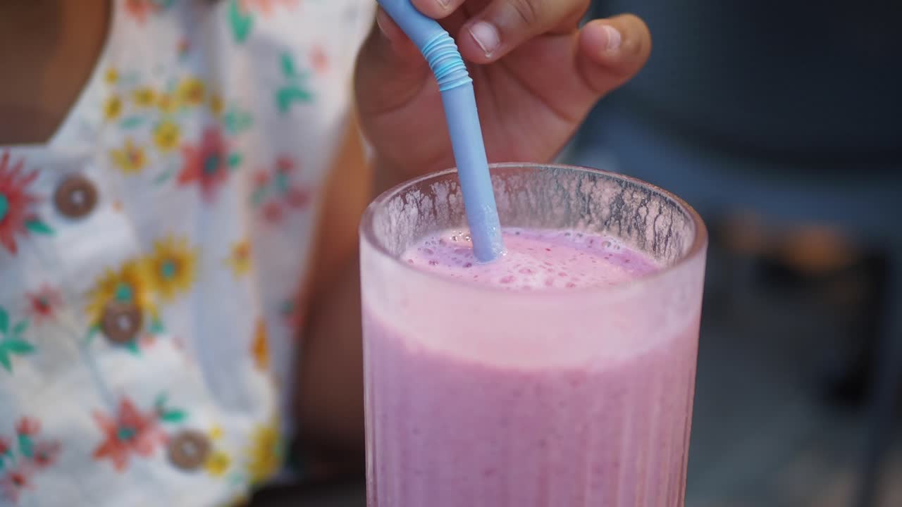 Young Girl Enjoying a Pink Smoothie