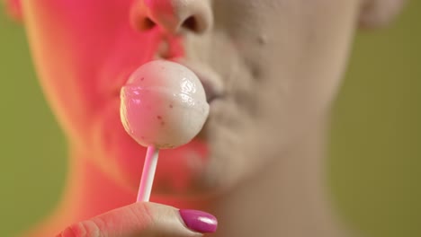 woman licking popsicle with seduction, mouth close-up shot on green background