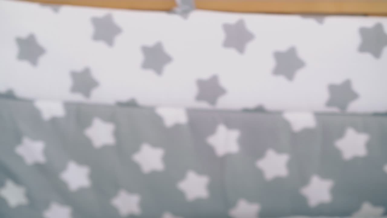 la mamma dondola una culla di legno con un piccolo figlio carino in una stanza luminosa