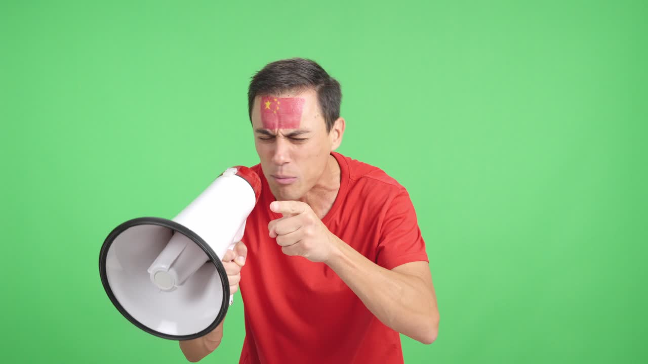Excited man with chinese flag on face using a megaphone