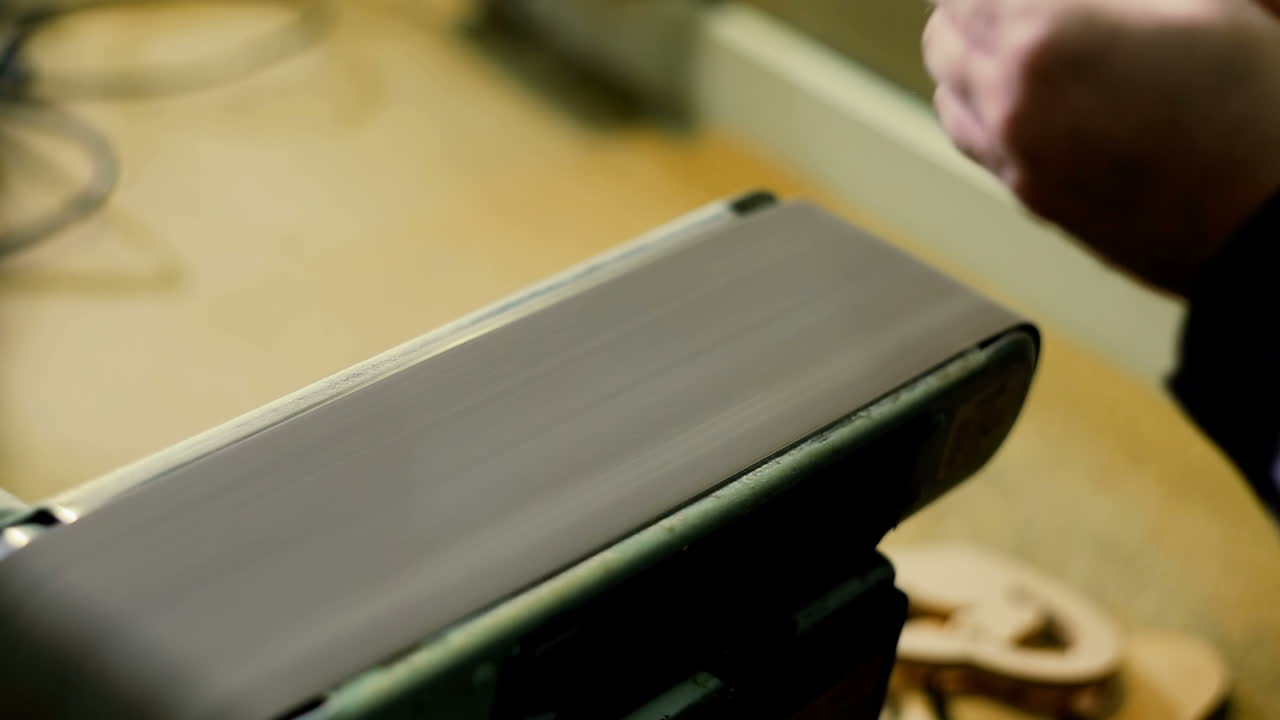Carpenter Sanding Furniture. Close-up of male carpenter sanding wood in his workshop