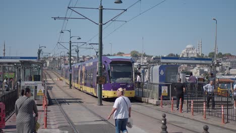 a purple tram arriving at a station in istanbul, turkey