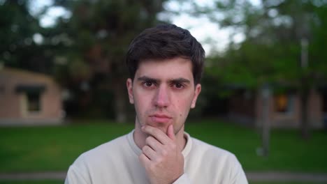 Closeup-Of-Young-Man-Outdoor,-Thinking-With-Hand-At-Chin