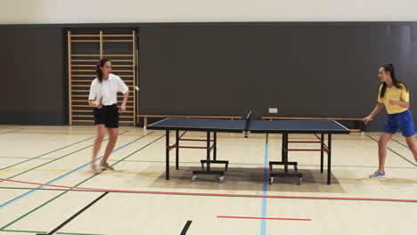 playing table tennis, two people competing in indoor sports hall