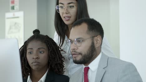 Focused-coworkers-using-desktop-computer