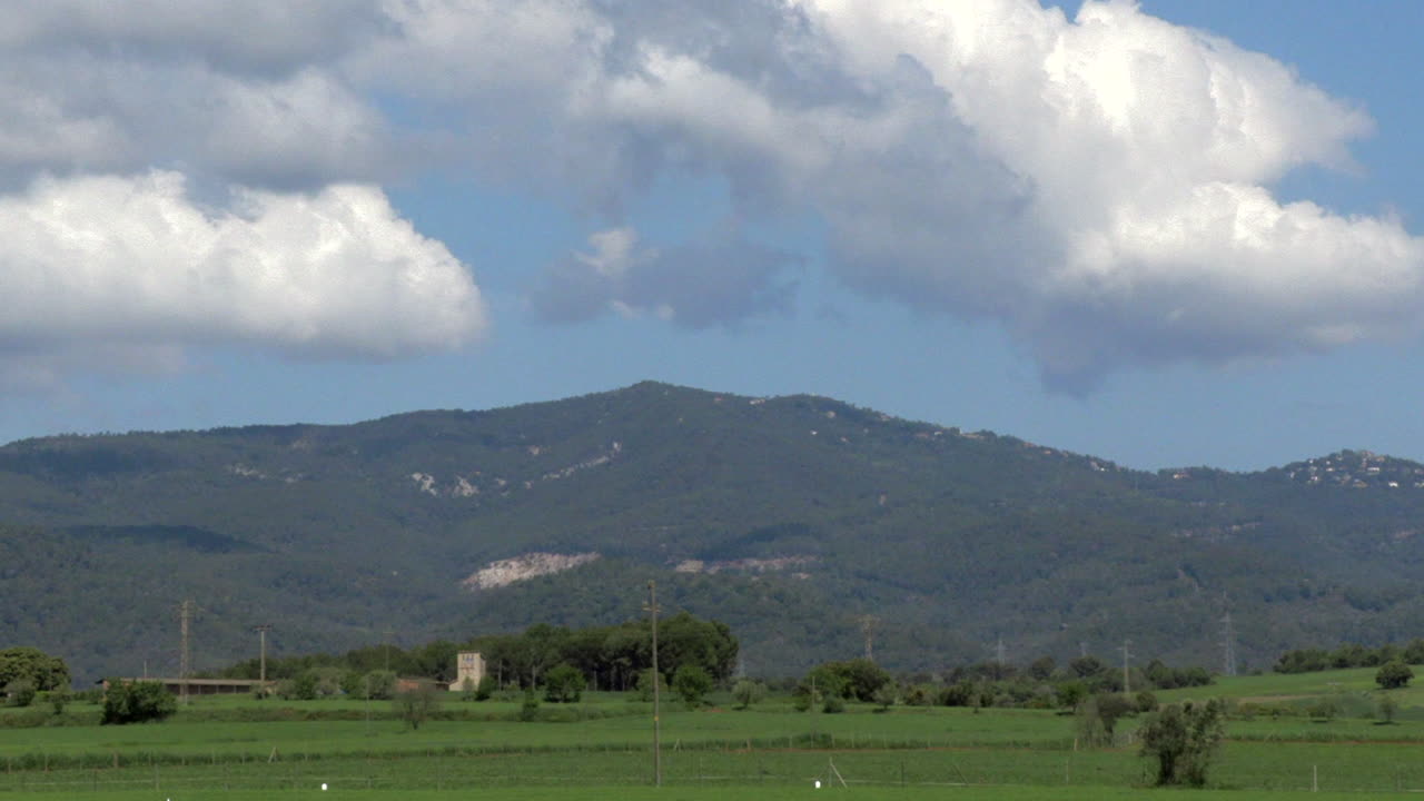 Timelapse zoom out of a sunny day at the base of the mountain. The clouds were moving fast that day in Spain countryside