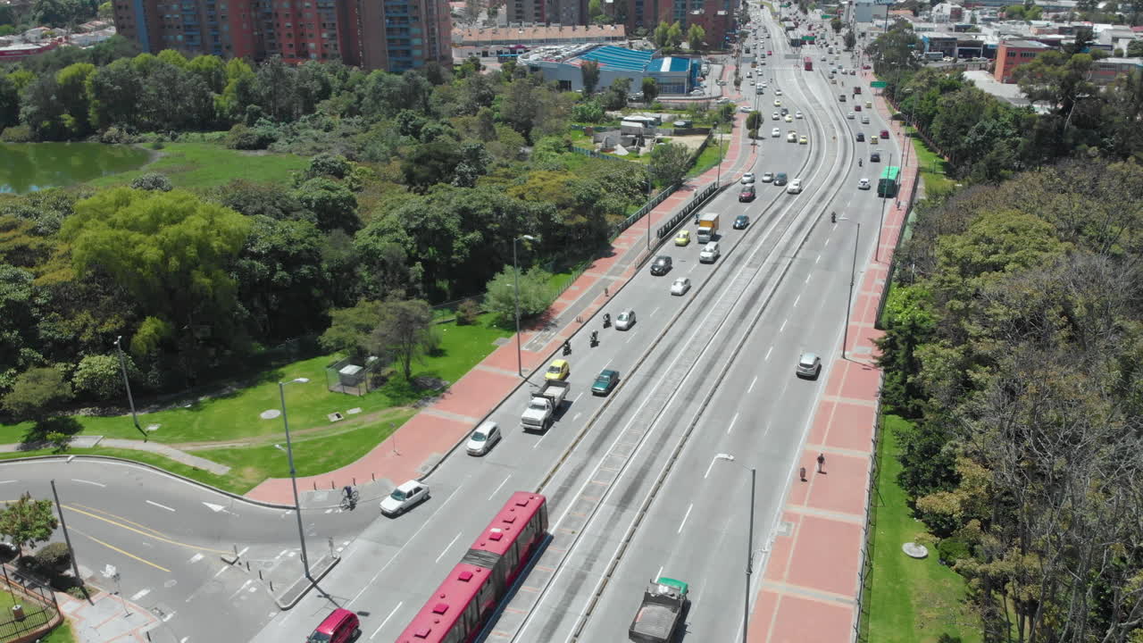 tráfico en bogotá - vehículos y autobuses articulados transmilenio circulando en carreteras de la ciudad de colombia