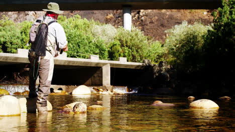 man fly fishing in river