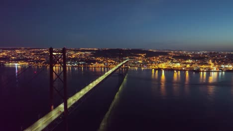 drone footage of the big bridge in lisbon and the city before sunrise