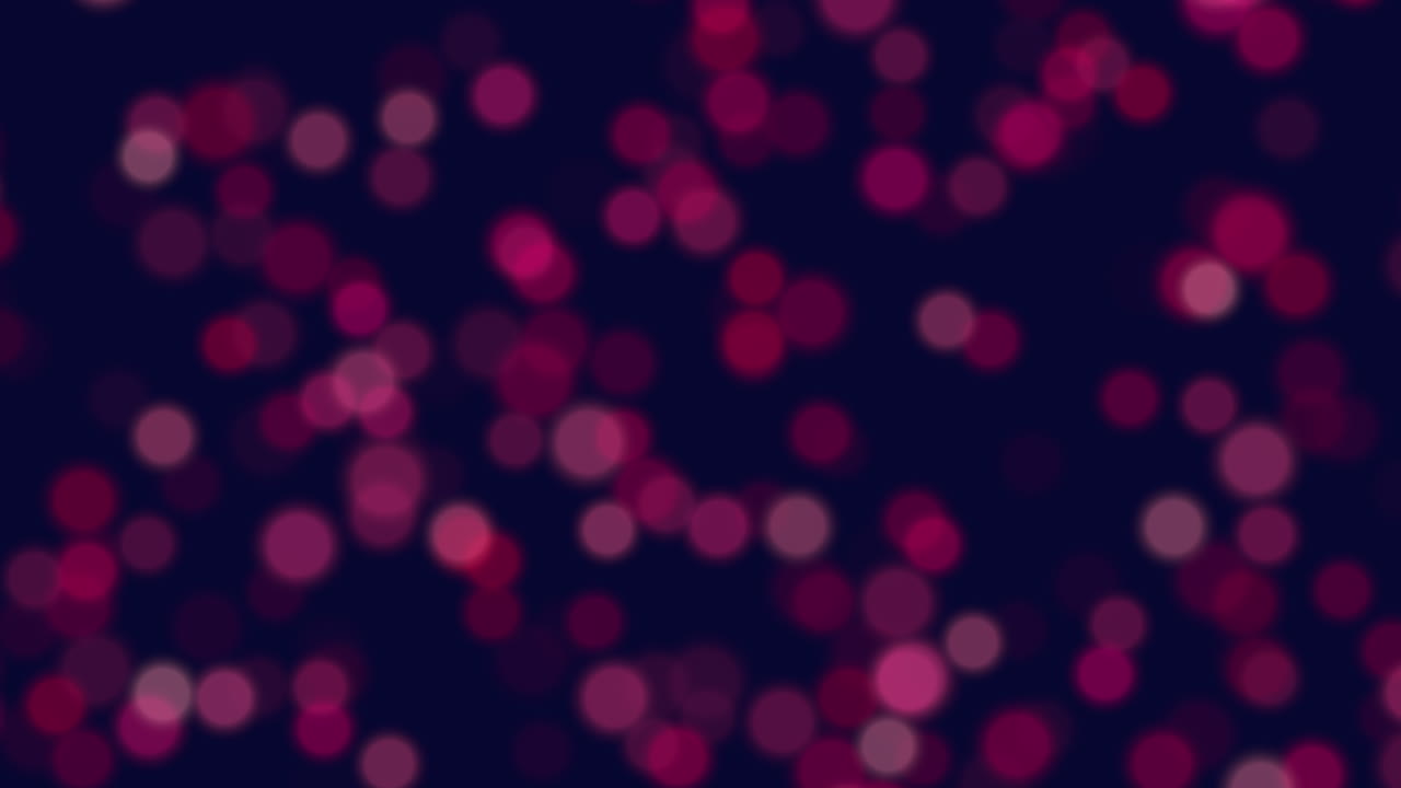 Circular pattern of purple and red dots in motion on a dark background. The vibrant colors and dynamic arrangement create a visually captivating display