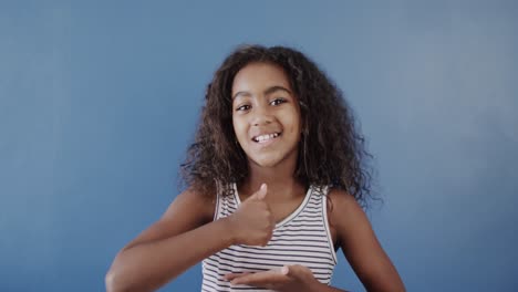 Happy-african-american-girl-using-sign-language-on-blue-background,-slow-motion