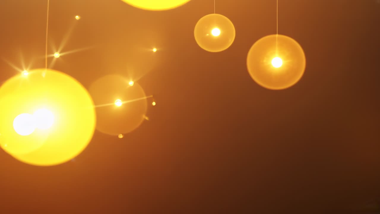 Panning camera revealing bright golden orb and lens flares over dark amber ceiling, pendant globes