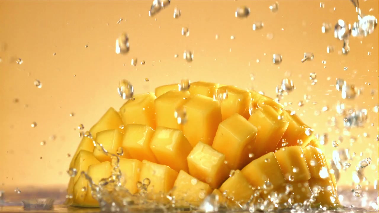 Acqua rinfrescante che schizza su un mango fresco a cubetti.