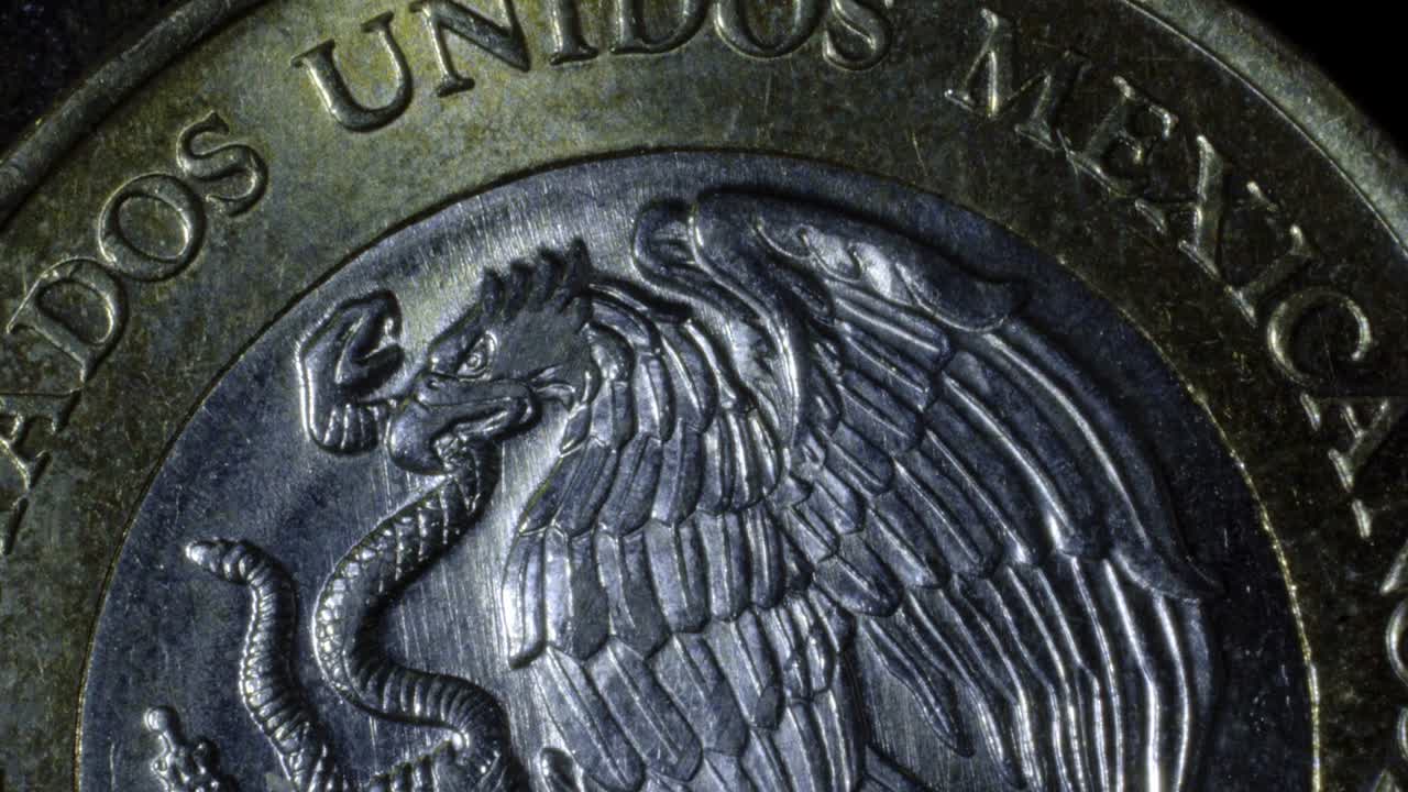Close-up of Mexican coin showing eagle and snake with detailed engraving