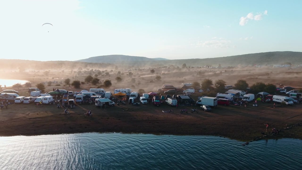 Aerial View of a Busy Campsite by a Lake at Sunset