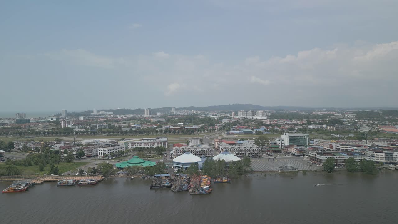 Splendida vista aerea con drone della città di Bintulu, Sarawak, con fiume, barca e piccola nave mercantile, accanto al mercato umido e, sullo sfondo, il nuovo ponte di Bintulu e anche una piccola pista di atterraggio inutilizzata.