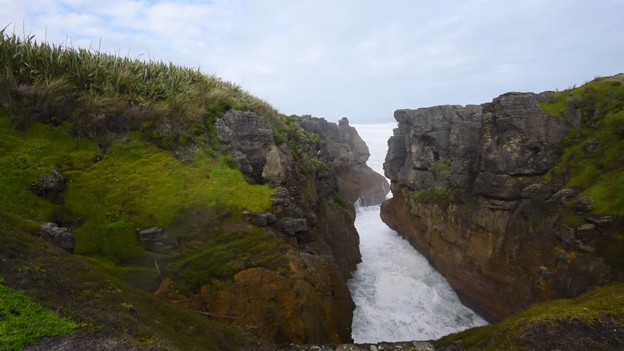Wild waves hitting into cliffs creating a blowhole
