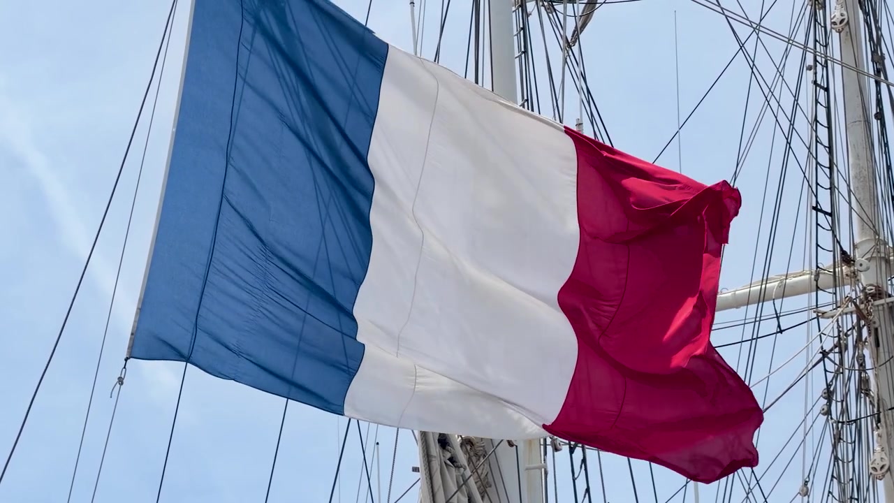 Fransk flag vajende på en skibsmast mod en klar himmel