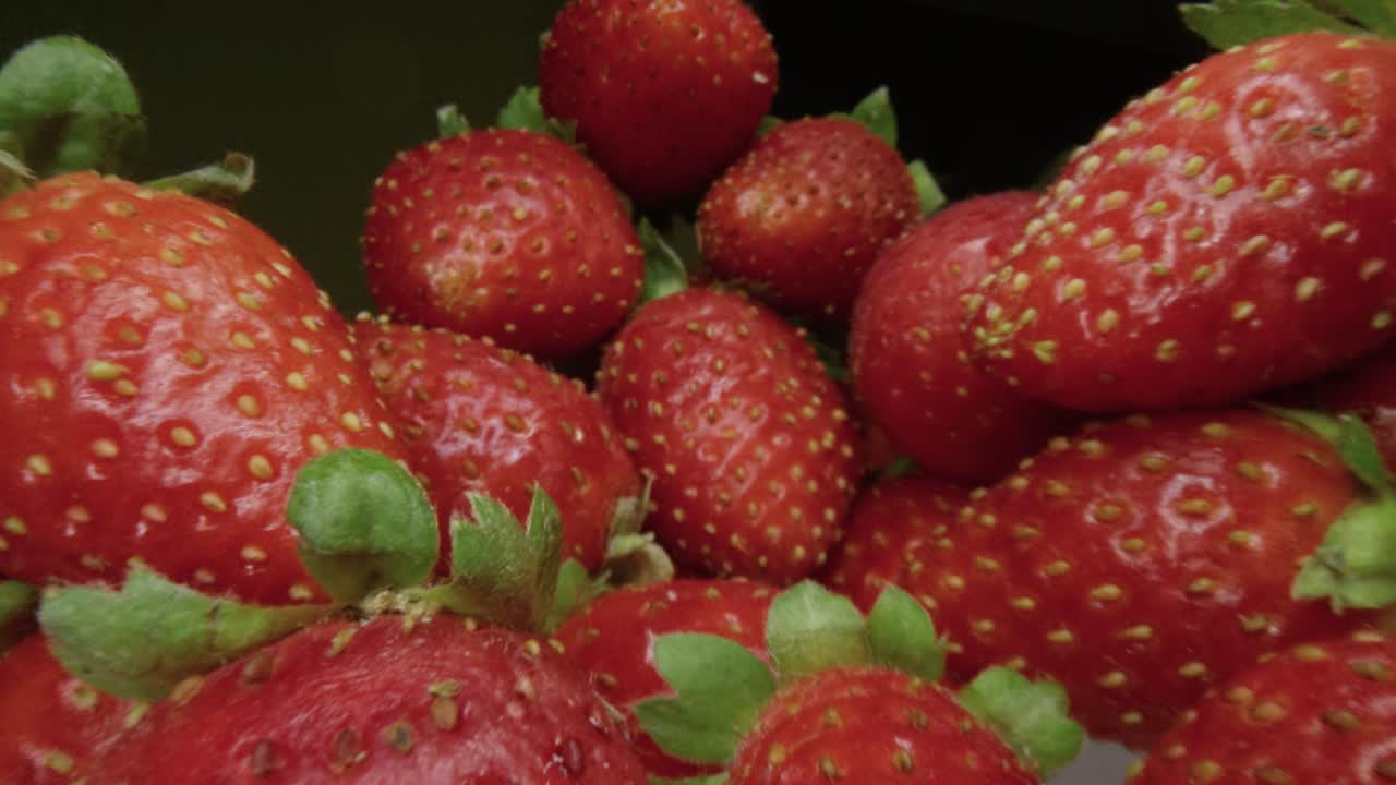 Macro Slide Ripe juicy strawberry. Healthy organic food. The camera moves through a heap of strawberries. Dolly shot using a probe lens. Red berries. Close-up. Type L.