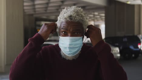 portrait of african american senior man wearing face mask in the parking lot