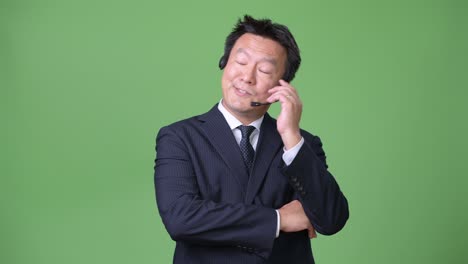 hombre de negocios japonés maduro contra un fondo verde