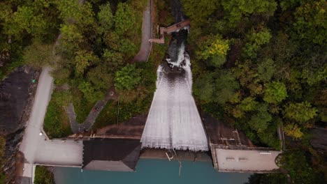 cascading waterfall from the mountains and lake klammsee in austria - aerial shot