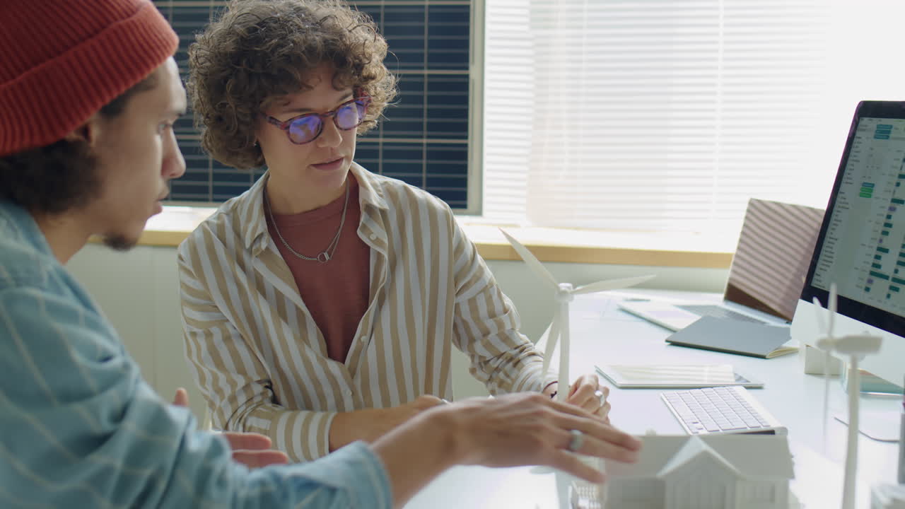 Female Engineer Discussing Wind Energy Project with Coworker