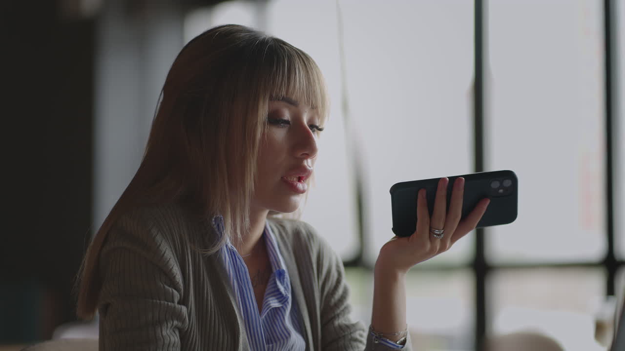 Asian woman recording voice recognition message on speakerphone. Businesswoman using virtual assistant app sets reminder on smart phone. Digital ai mobile assistance tech concept. audio message.